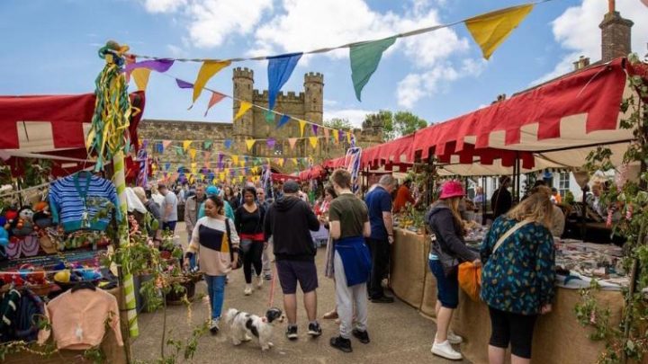 Outdoor market with stalls and visitors in historic Battle, East Sussex