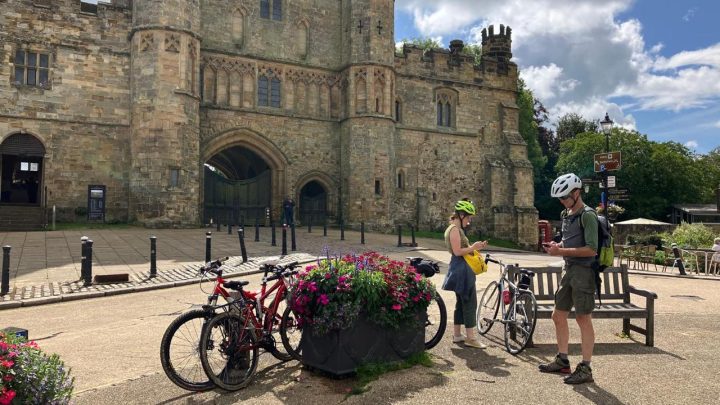 Cyclists with bikes outside Battle Abbey in Battle, East Sussex