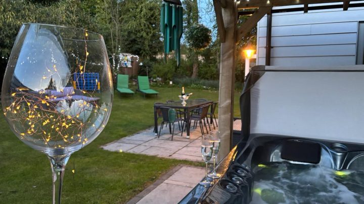 Hot tub and garden seating area at Blackfirs Farmhouse in the evening