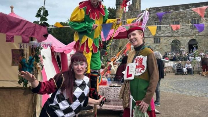 Colourful performers entertaining visitors at a family event near Battle Abbey