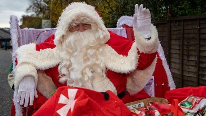 Father Christmas waving during a festive event near Battle
