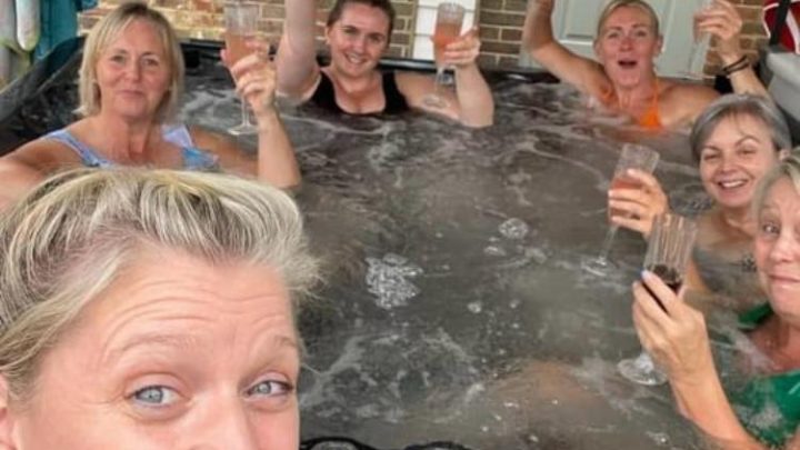 Friends relaxing together in the private hot tub at Blackfirs Farmhouse