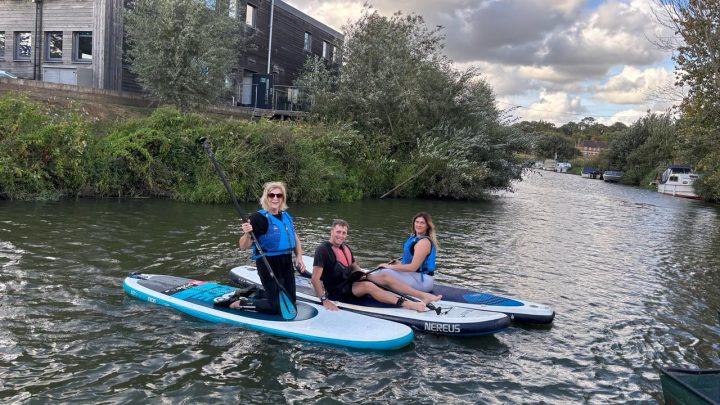 Group relaxing on paddleboards during an outdoor activity in East Sussex