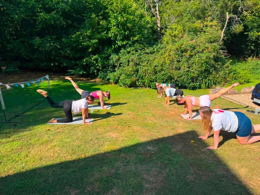 Group enjoying an outdoor wellness session in the garden at Blackfirs Farmhouse